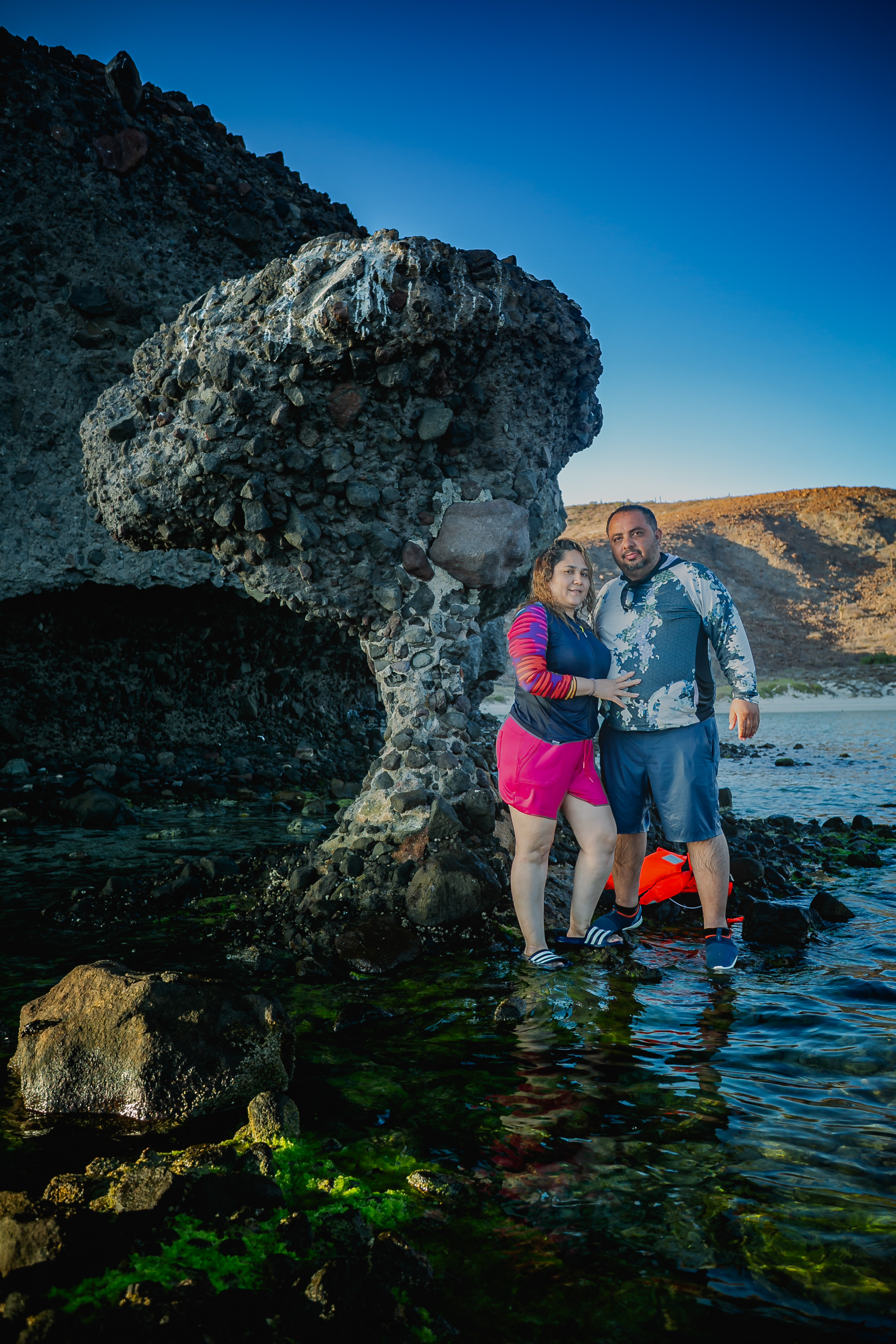 Familia junto a la emblemática formación rocosa de Balandra